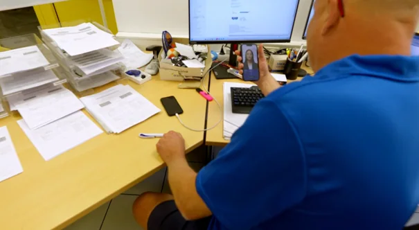 Arbeitsplatz mit Papierstapeln und Bildschirm